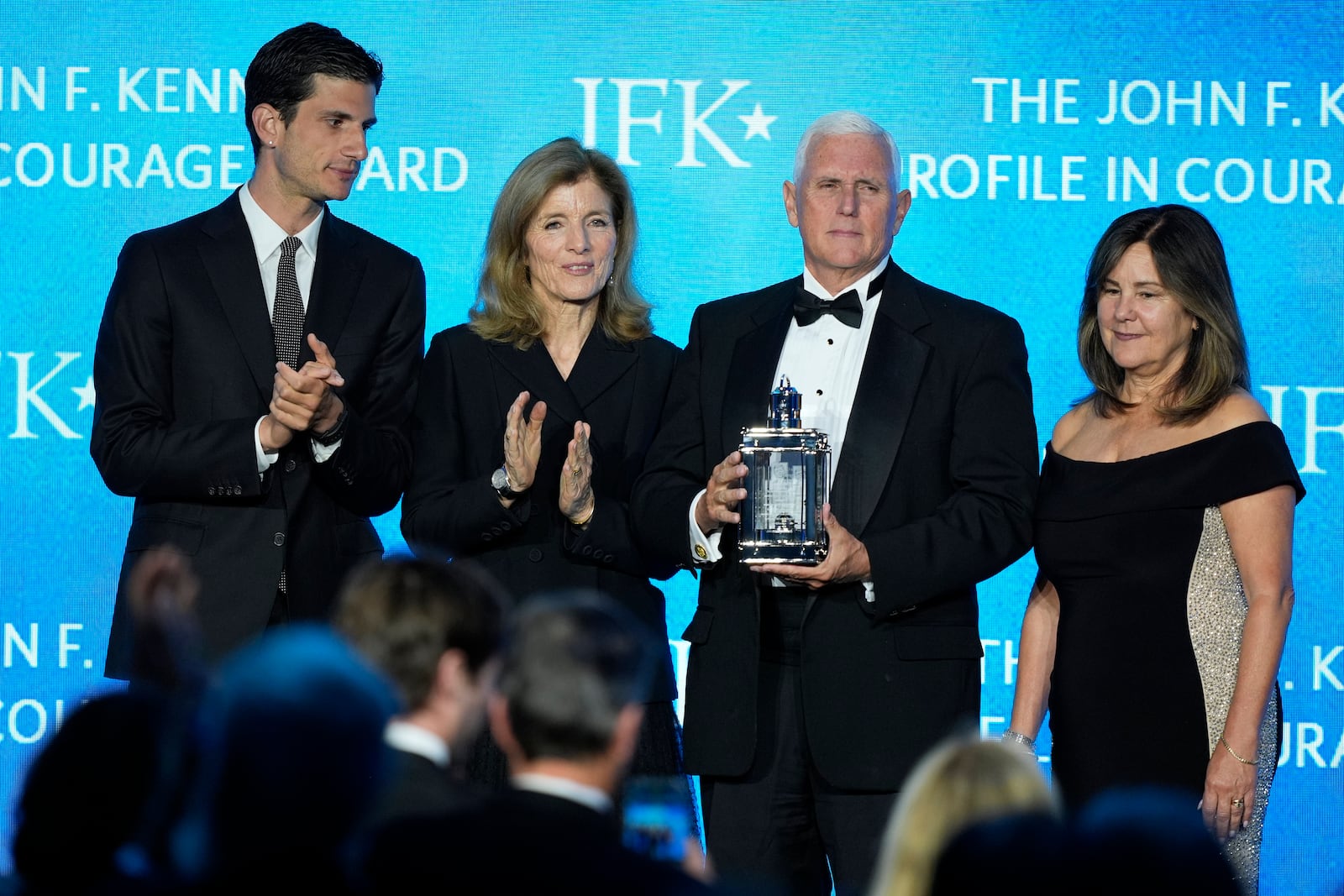 Former Vice President Mike Pence, second from right, stands with his wife, Karen Pence, far right, as he is presented with the John F. Kennedy Profile in Courage Award by Jack Schlossberg and his mother, Caroline Kennedy, at a ceremony at the JFK Library, Sunday, May 4, 2025, in Boston. (AP Photo/Robert F. Bukaty)