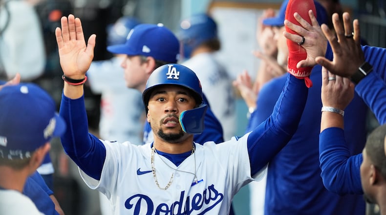 Los Angeles Dodgers' Mookie Betts celebrates in the dugout after scoring against the Milwaukee Brewers during the first inning in Game 4 of baseball's National League Championship Series, Friday, Oct. 17, 2025, in Los Angeles. (AP Photo/Ashley Landis)