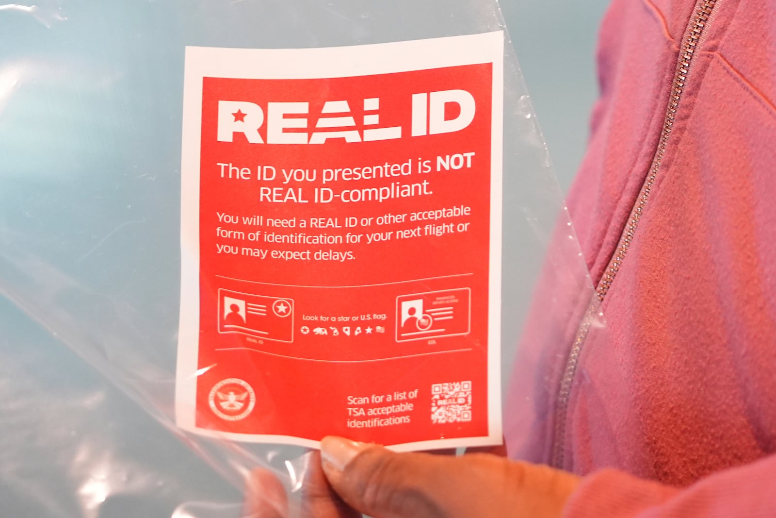 Tekeda Jones shows a document she was given to travel through Love Field airport in Dallas, Wednesday, May 7, 2025. (AP Photo/LM Otero)