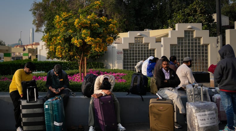 Passengers stranded by the closure of Dubai International Airport await for assistance in the airport parking lot in Dubai, United Arab Emirates, Sunday, March 1, 2026. (AP Photo/Altaf Qadri)