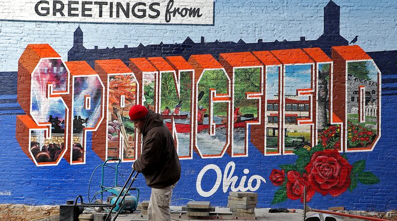 A worker from Gillam Lawncare and Landscaping smooths out the gravel beneith pavers his crew was installing for a new pocket park along Fountain Avenue in downtown Sprigfield Monday. BILL LACKEY/STAFF