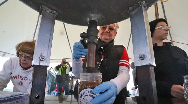 Volunteers fill jars of hot apple butter Saturday, Oct. 8, 2022 at the Enon Apple Butter Festival. BILL LACKEY/STAFF
