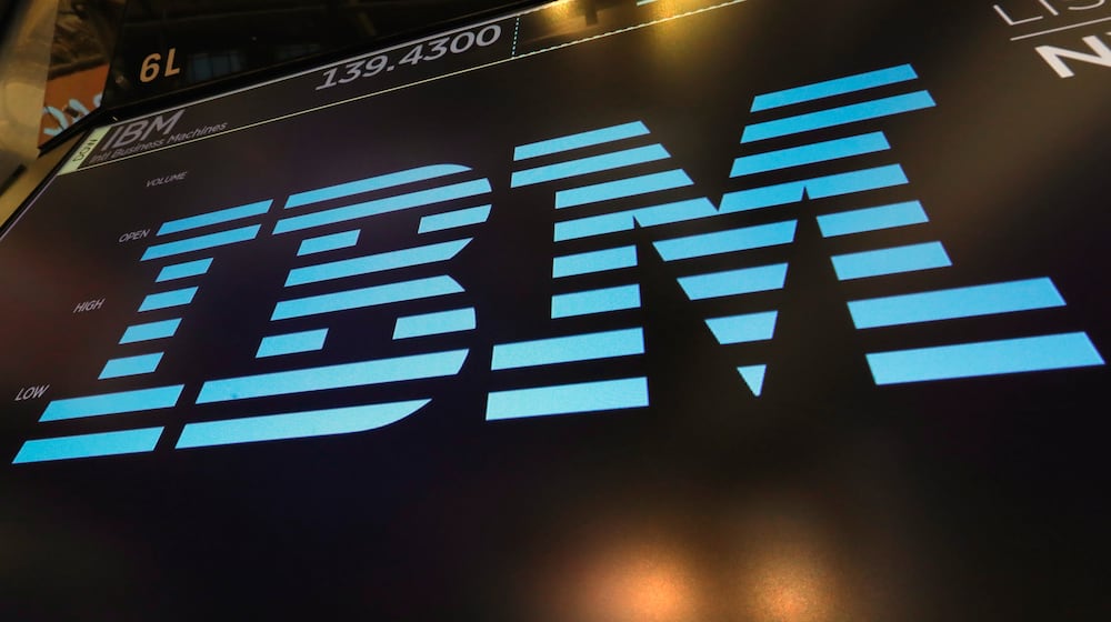 FILE - The logo for IBM appears above a trading post on the floor of the New York Stock Exchange, March 18, 2019. (AP Photo/Richard Drew, File)