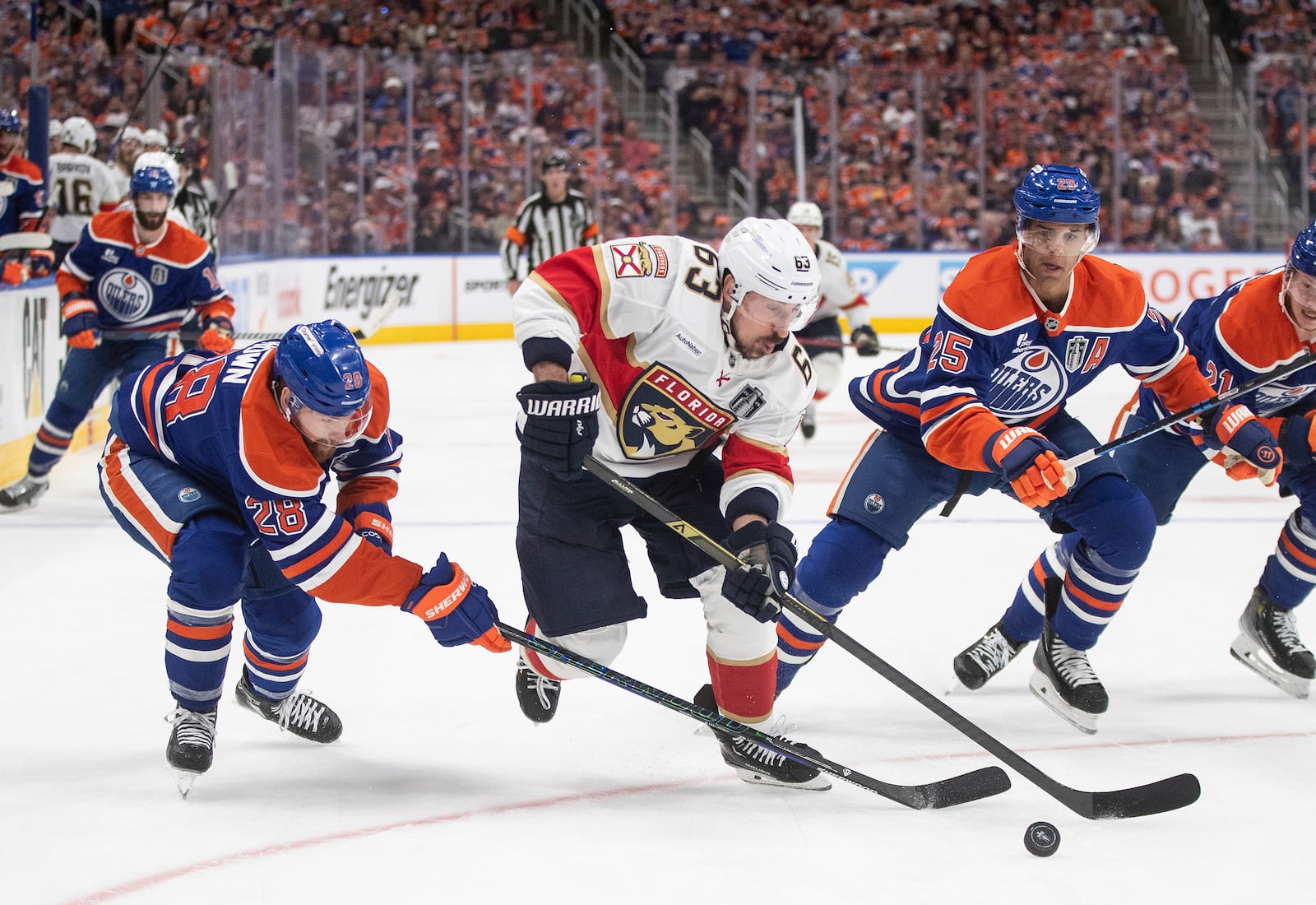 Florida Panthers' Brad Marchand (63) is chased by Edmonton Oilers' Connor Brown (28) and Darnell Nurse (25) during the third period in Game 1 of the NHL hockey Stanley Cup final series in Edmonton, Alberta, Wednesday, June 4, 2025. (Jason Franson/The Canadian Press via AP)