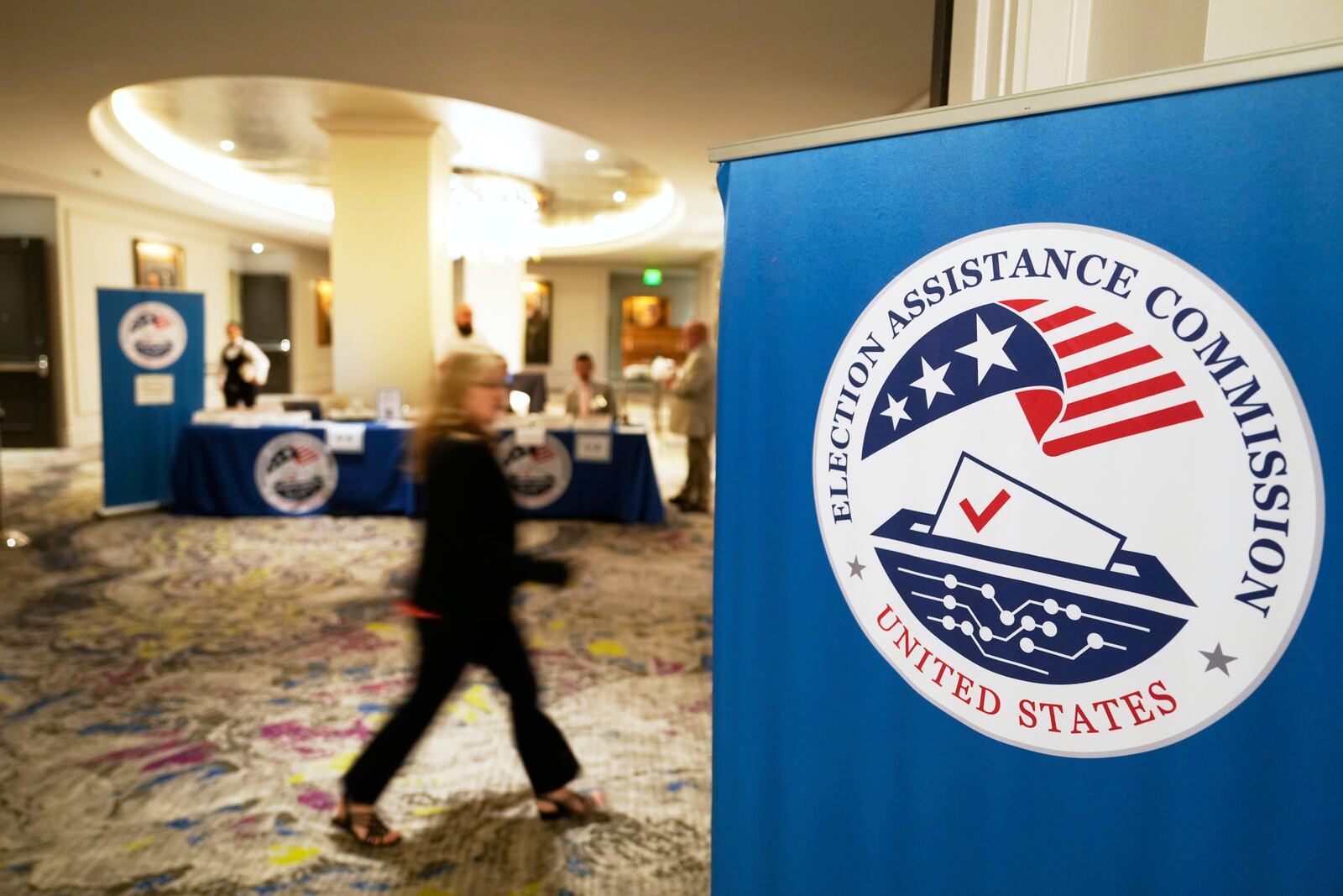 A meeting goer arrives for a U.S. Election Assistance Commission Standards Board in-person public meeting, Thursday, April 24, 2025, in Charlotte, N.C. (AP Photo/Chris Carlson)