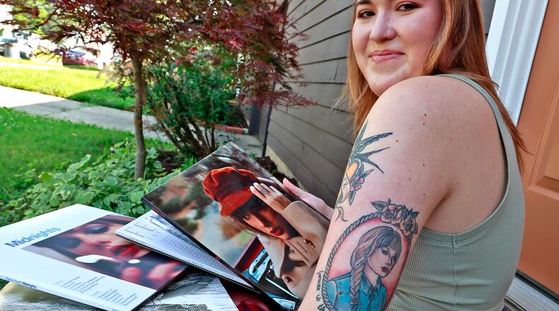 Maggie Bowen, from Springfield, shows off her Taylor Swift tattoo as she looks through her Taylor Swift album collection Wednesday, June 21, 2023. Bowen is attending the Taylor Swift concert in Cincinnati and another Swift concert in Denver. BILL LACKEY/STAFF