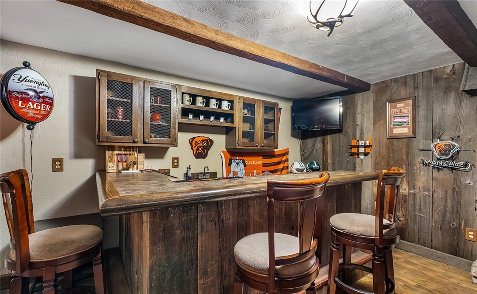 The finished basement has a recreation room with beamed ceiling, LVT flooring and a wood bar with built in cabinets. CONTRIBUTED