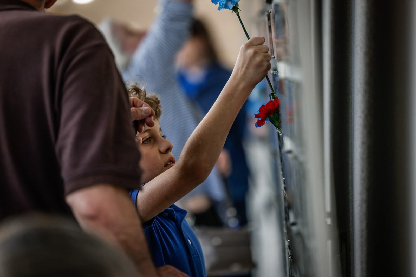 The Air Force Museum held its first Honor Plate Ceremony since the pandemic three years ago. A total of 475 new names were added to the wall. After the ceremony, family and friends hung flowers near their loved one's plates. JIM NOELKER/STAFF