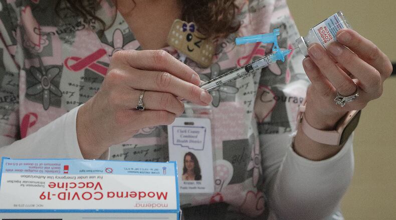 A nurse gets a COVID vaccine shot ready at the Clark County Combined Health District's vaccine center. BILL LACKEY/STAFF