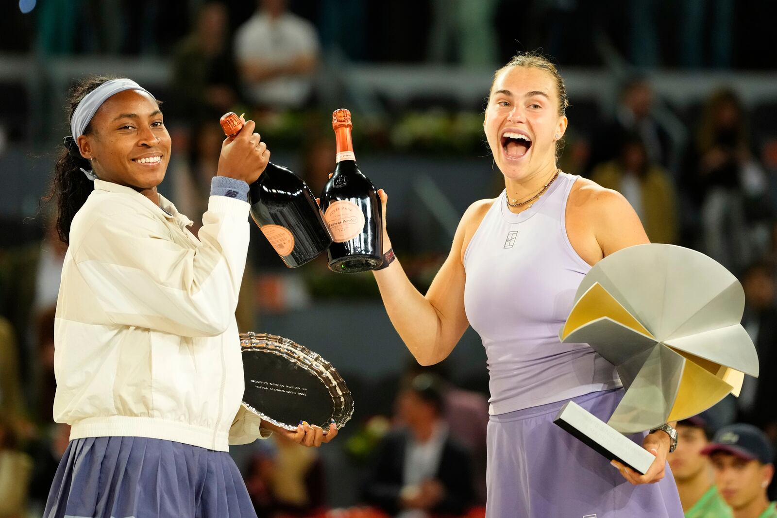 United States' Coco Gauff, left, and the winner Aryna Sabalenka of Belarus stand on the podium after the Madrid Open tennis final in Madrid, Spain, Saturday, May 3, 2025. (AP Photo/Jose Breton)