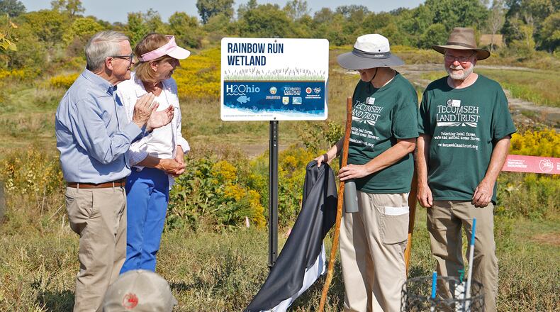 Gov. Mike DeWine and his wife, Fran, along Susan and Tom Miller unveil the sign for the new H2Ohio Rainbow Run Wetland on Old Clifton Road in Clark County Wednesday, Sept. 11, 2024. Tom and Susan Miller are the couple that donated the land for the wetland. BILL LACKEY/STAFF