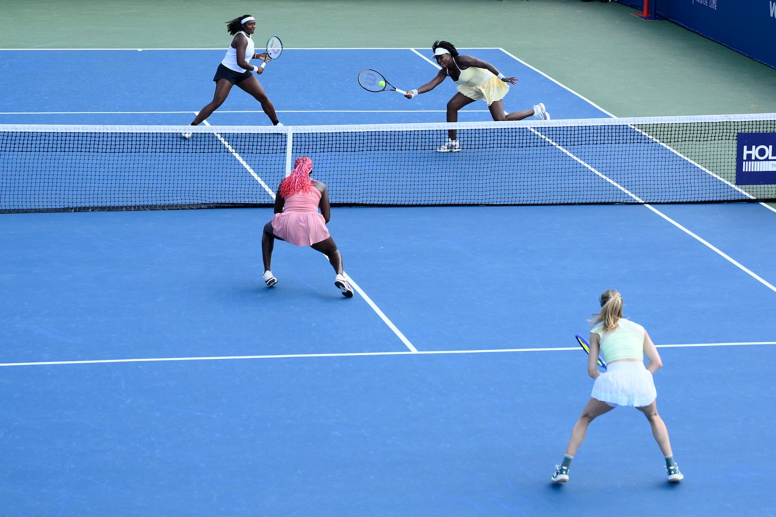 Hailey Baptiste, top left, and Venus Williams top right, compete during a doubles match against Eugenie Bouchard, bottom right, and Clervie Ngounoue, bottom left, at the Citi Open tennis tournament Monday, July 21, 2025, in Washington. (AP Photo/Nick Wass)