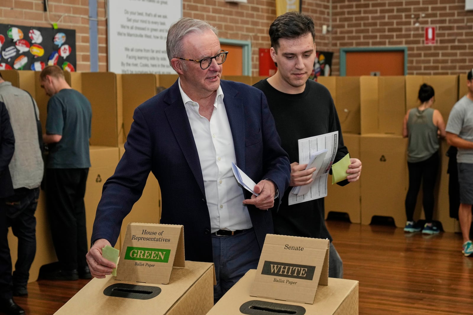 Australian Prime Minister Anthony Albanese and his son Nathan place their votes in a ballot box at a polling booth in his electorate in Sydney, Saturday, May 3, 2025. (AP Photo/Rick Rycroft)