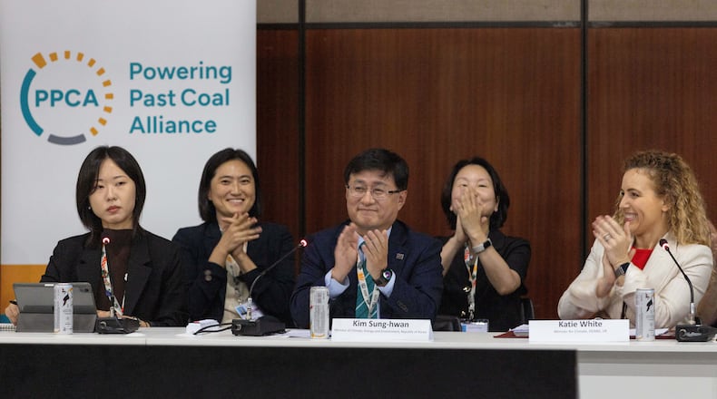 Kim Sung-hwan, center, the inaugural head of South Korea's new Ministry of Climate, Energy and Environment, applauds after he made the announcement of South Korea joining the Powering Past Coal Alliance, during U.N. climate talks in Belem, Brazil, Nov. 17, 2025. (AP Photo/Anton L. Delgado)