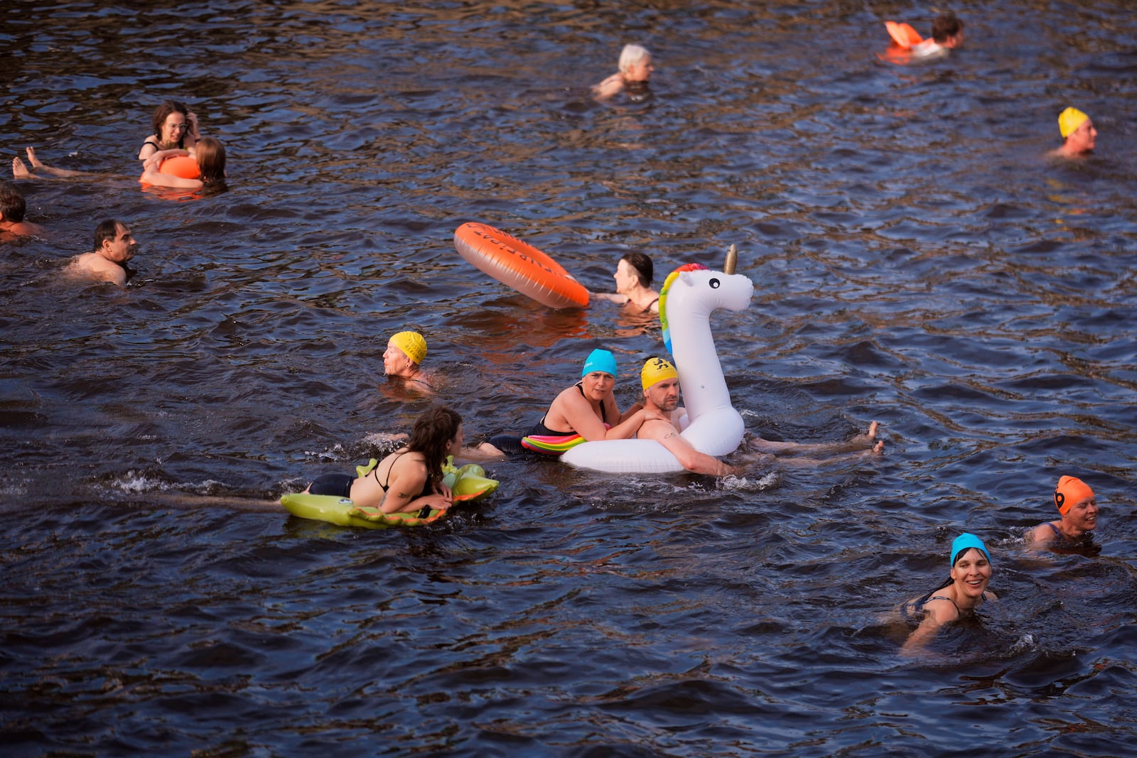 People swim in the river Spree to demand the lift of the hundred years old swimming ban at the river in Berlin, Germany, Tuesday, June 17, 2025. (AP Photo/Markus Schreiber)