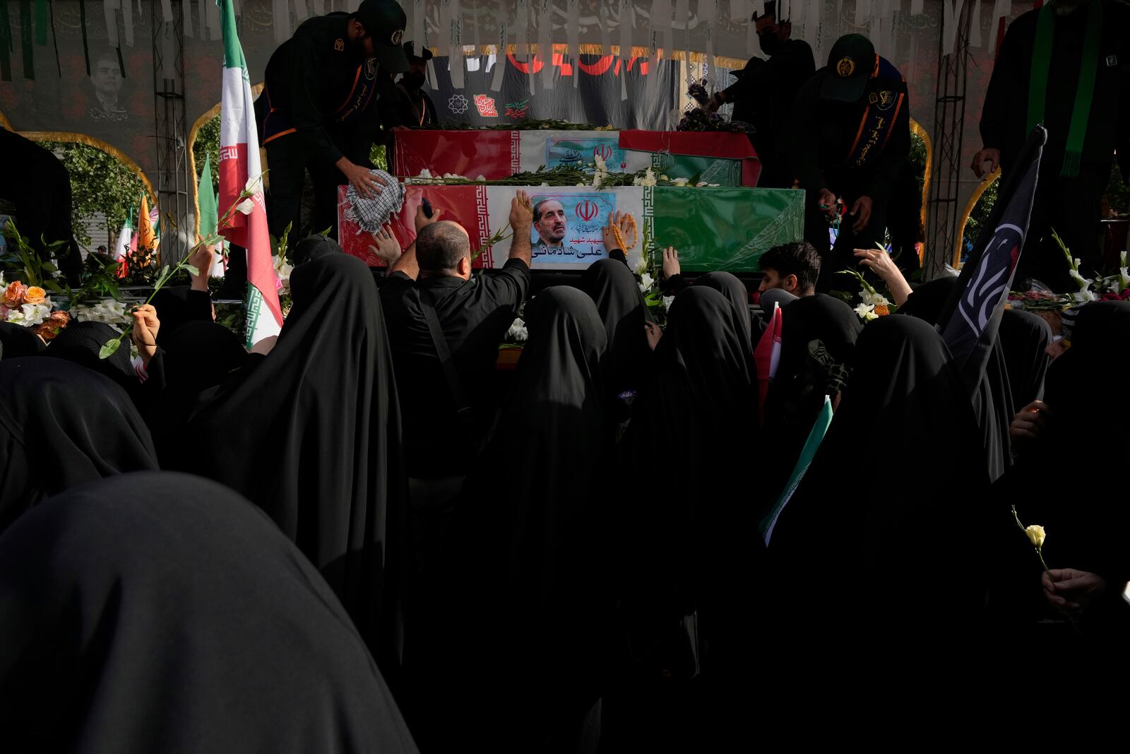 Mourners try to touch the flag-draped coffins during the funeral ceremony of the Iranian armed forces generals, nuclear scientists and their family members who were killed in Israeli strikes, at Enqelab-e-Eslami (Islamic Revolution) square, in Tehran, Iran, Saturday, June 28, 2025. (AP Photo/Vahid Salemi)
