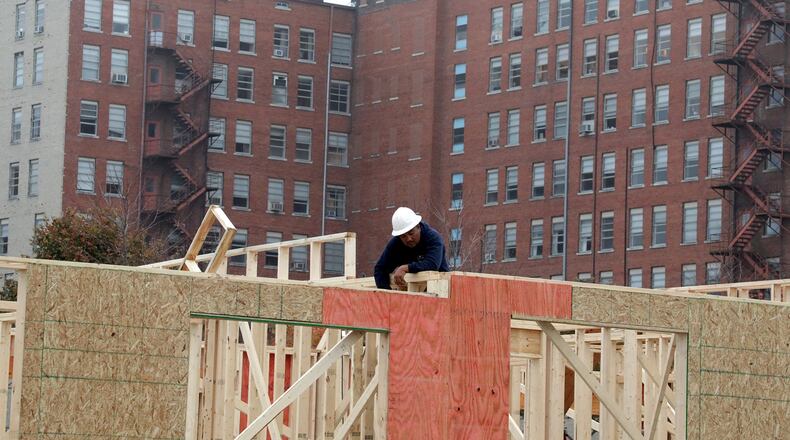Hull Plaza rises up behind a construction worker framing the new Center Street Townhomes in downtown Springfield. The townhomes are just one of several projects that are changing the face of downtown Springfield. BILL LACKEY/STAFF