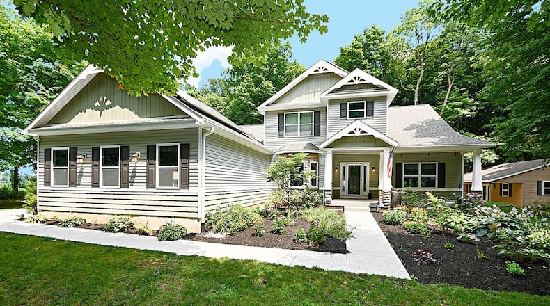 The 4-bedroom home sits back on the wooded lot, and the front features a covered front porch, attached 3-car garage and professional landscaping. CONTRIBUTED PHOTO