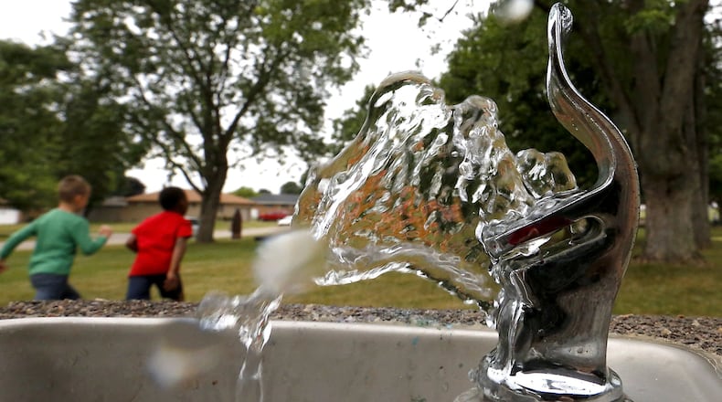 Water shoots out of the drinking fountain at Moorefield Family Park as children play in the background. FILE