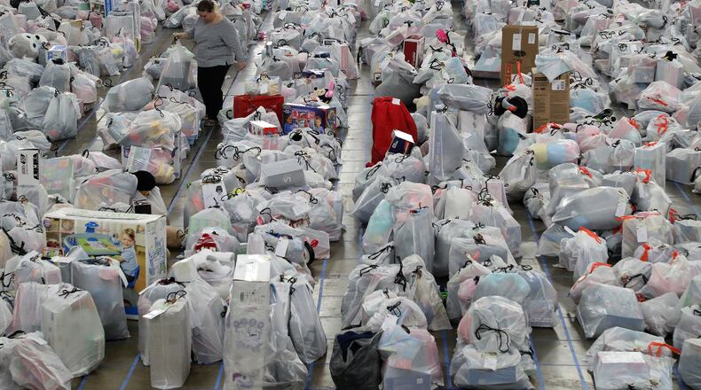 ORIGINAL CUTLINE: Melissa Jeffery, a Salvation Army volunteer, walks through a sea of plastic bags, each containing Christmas presents for a needy child, as she helps sort presents for the more than 2,000 children the Springfield Salvation Army is helping this Christmas. BILL LACKEY/STAFF