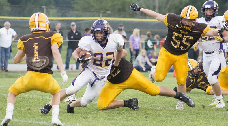 Mechanicsburg’s Joey Mascadri runs through a hole in the Kenton Ridge defense toward Andrew Good, 1, and away from Brandon Collins, 55, during Friday night’s season opener at Kenton Ridge. Jeff Gilbert/CONTRIBUTED