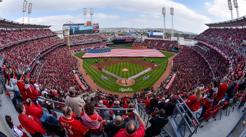 Thousands of fans stand during the National Anthem prior to the start of the Reds Opening Day game against Philadelphia Monday, April 4 at Great American Ball Park in Cincinnati. NICK GRAHAM/STAFF