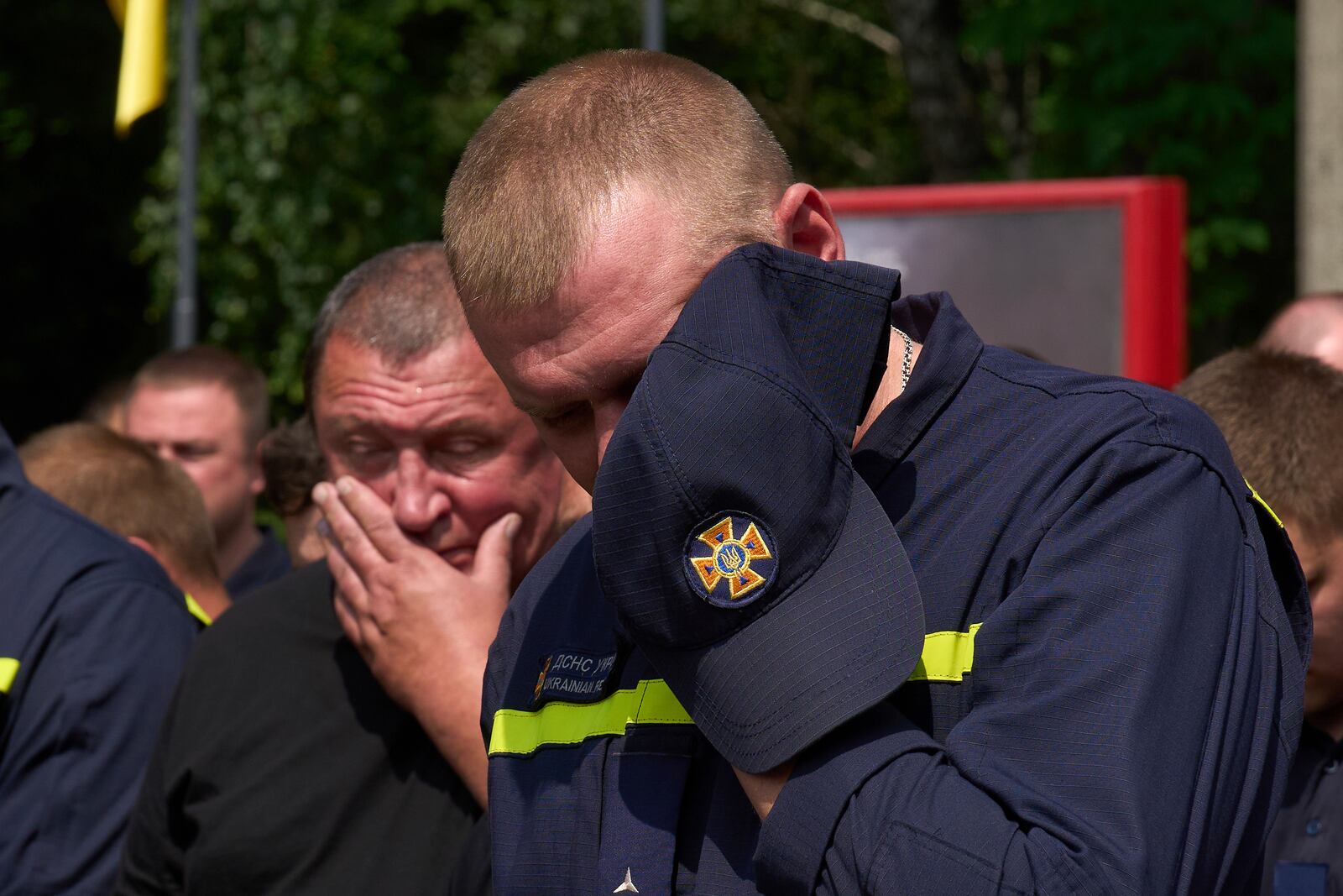 Colleagues are overcome by emotion as say the last goodbye to firefighters Pavlo Yezhor, Danylo Skadin, and Andriy Remenny, killed by Russia's missile attack last week, at the farewell ceremony in front of the fire station in Kyiv, Ukraine, Monday, June 9, 2025. (AP Photo/Efrem Lukatsky)