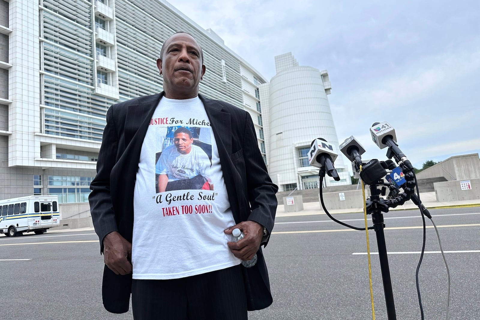 George Johnson stands outside federal court in Central Islip, N.Y. on Wednesday, July 2, 2025 wearing a shirt bearing an image of his son, Michael Johnson, who was slain by MS-13 gang members in 2016. (AP Photo/Philip Marcelo)