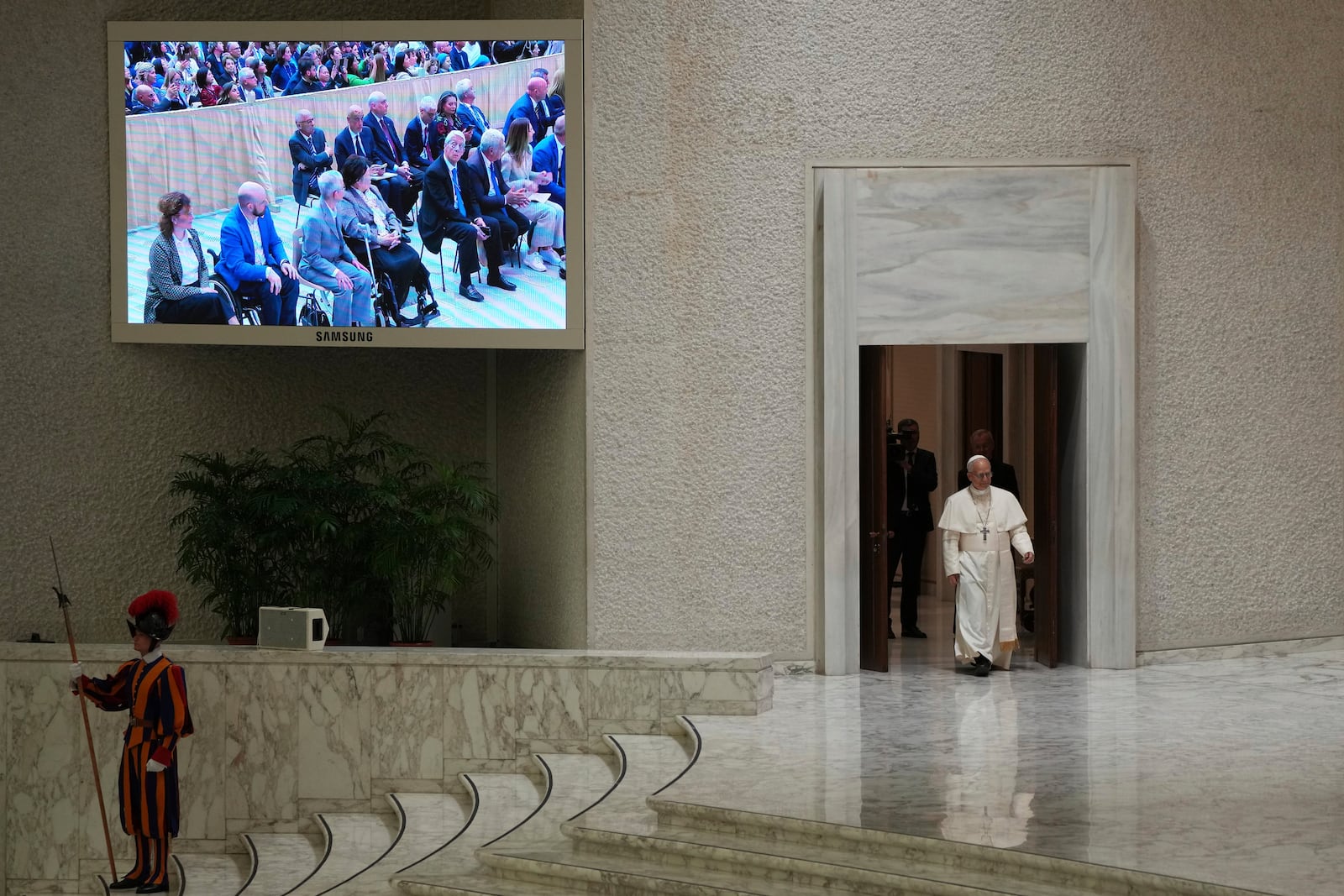 Pope Leo XIV arrives as he meets members of the international media in the Paul VI Hall at the Vatican, Tuesday, May 13, 2025. (AP Photo/Domenico Stinellis)