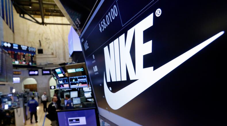 FILE - The Nike logo appears above the post where it trades on the floor of the New York Stock Exchange, March 22, 2017. (AP Photo/Richard Drew, File)