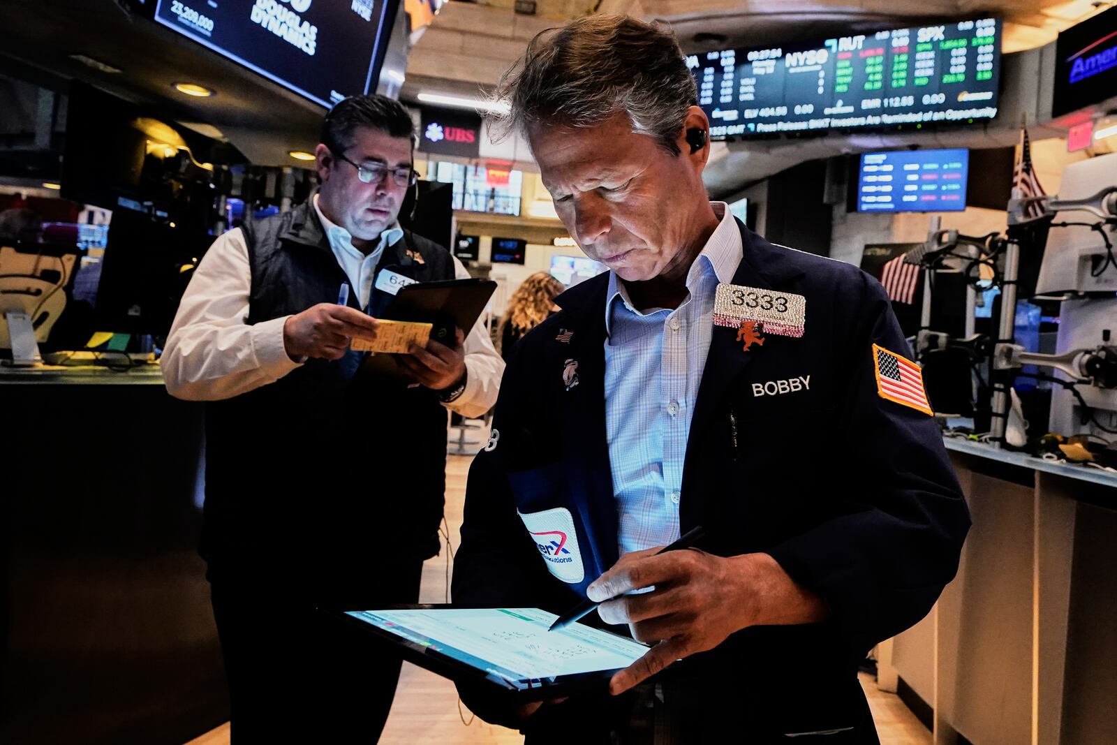 Traders Michael Capolino, left, and Robert Charmak work on the floor of the New York Stock Exchange, Monday, May 12, 2025. (AP Photo/Richard Drew)