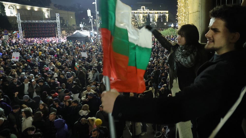 Students wave Bulgarian flag as as a swelling crowd of tens of thousands of Bulgarians filled Sofia's central square, demanding the government's resignation amid rising anger over corruption and contested economic policies, Sofia, Bulgaria, Wednesday, Dec. 10, 2025. (AP Photo/Valentina Petrova)