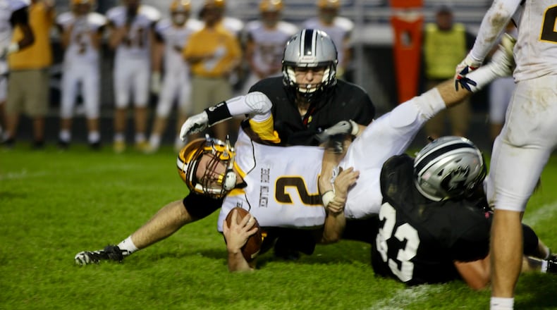 Kenton Ridge High School quarterback Dylan Lemen is tackled by three Graham defenders during the Cougars’ 42-14 victory Friday night at Dallas Stadium. Michael Cooper/STAFF