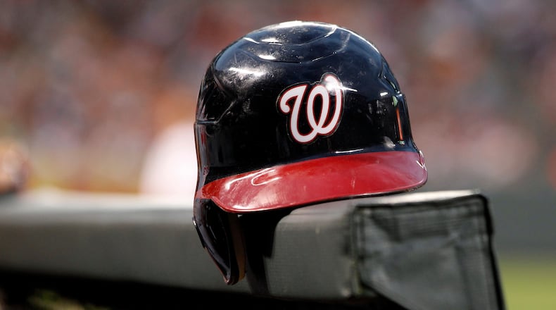 FILE - A Washington Nationals helmet sits in the dugout railing before a baseball game against the Baltimore Orioles in Baltimore, June 22, 2012. (AP Photo/Patrick Semansky, File)