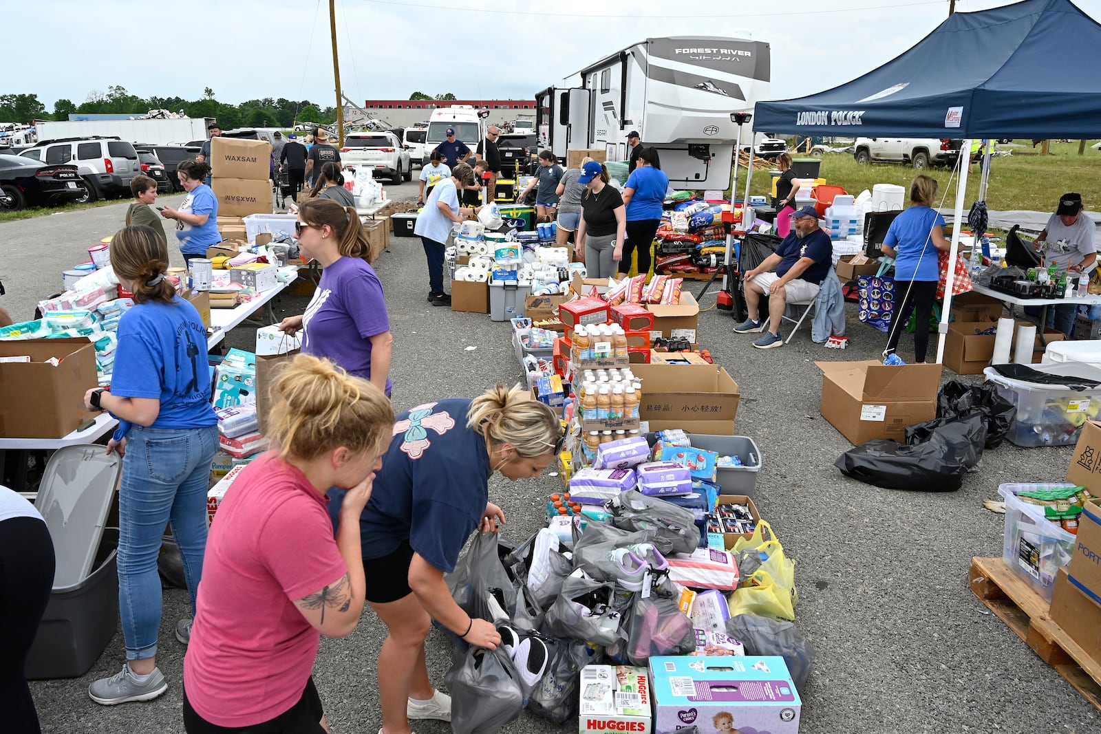 Volunteers sort food and clothing for distribution at the command center at the London-Corbin Airport in London, Ky., Monday, May 19, 2025. (AP Photo/Timothy D. Easley)