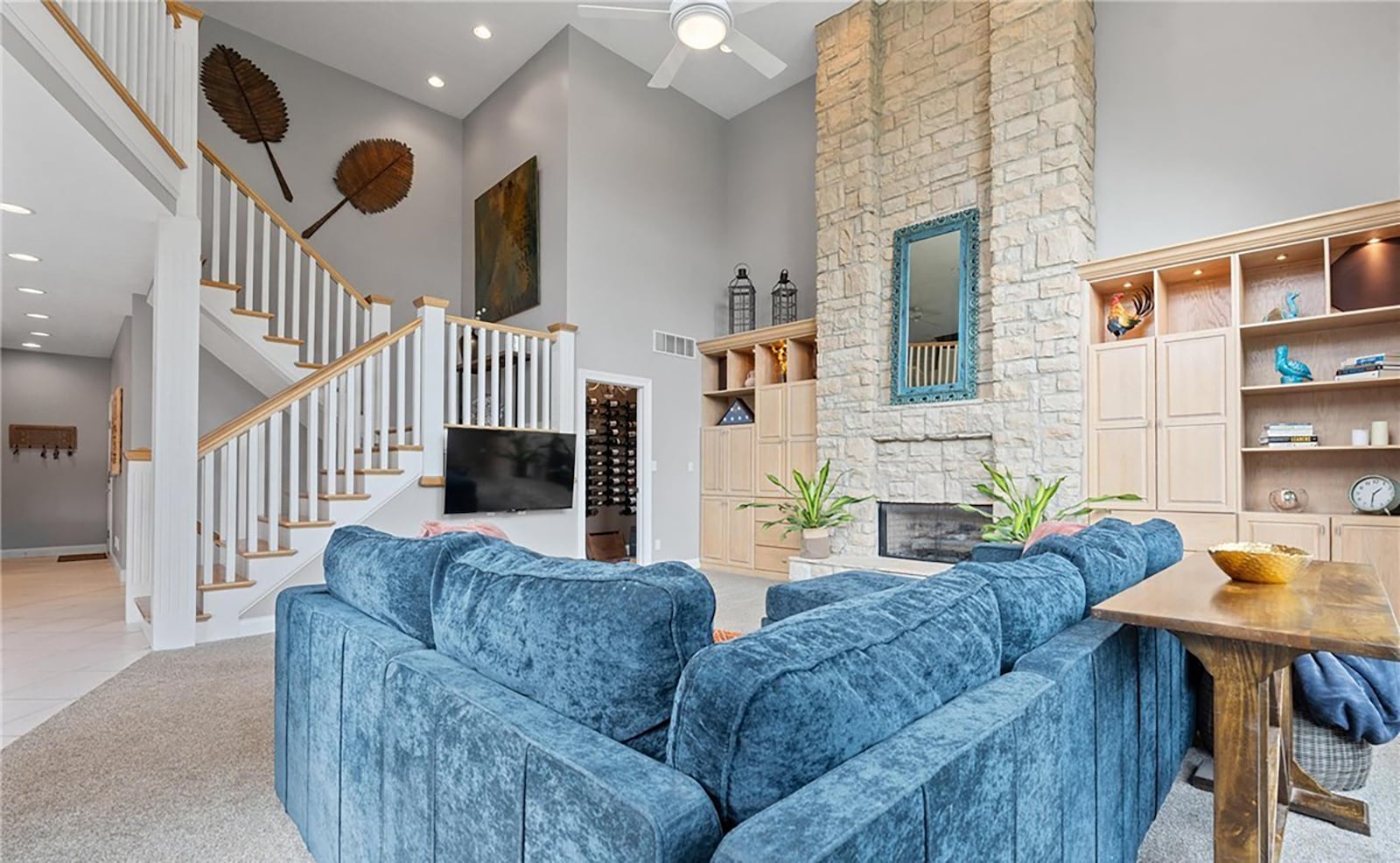 The two story family room is carpeted and has a floor to ceiling stone fireplace flanked by built ins. CONTRIBUTED