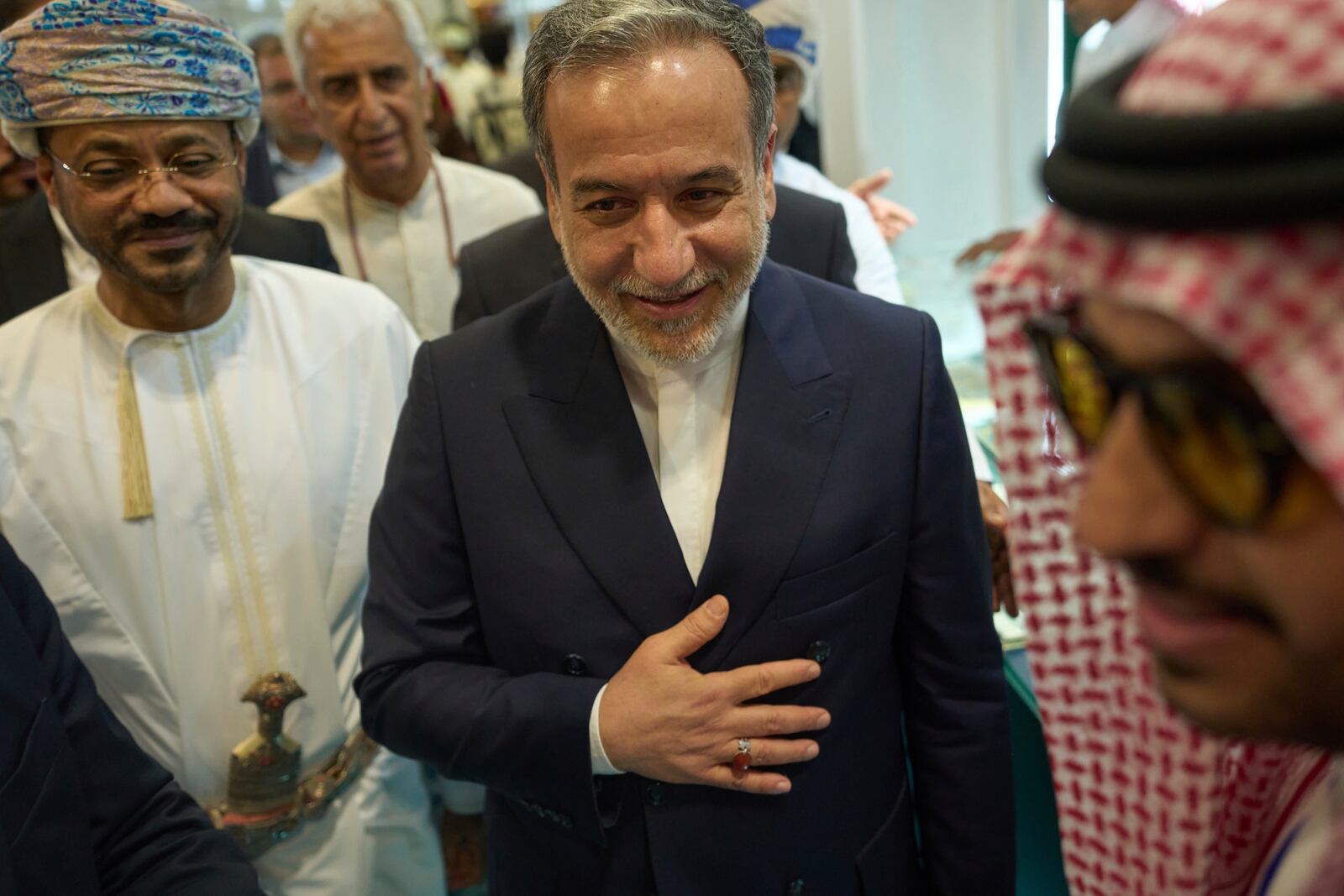 Iranian Foreign Minister Abbas Araghchi, center, and Omani Foreign Minister Badr al-Busaidi, left, walk through the Muscat International Book Fair in Oman, Friday, April 25, 2025. (AP Photo/Fatima Shbair)