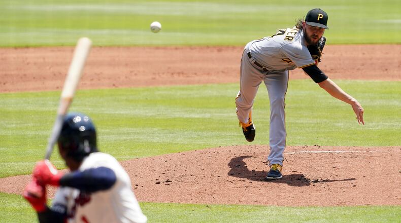 Pittsburgh Pirates' J.T. Brubaker, right, throws to an Atlanta Braves batter in the first inning of a baseball game Sunday, May 23, 2021, in Atlanta. (AP Photo/Tami Chappell)