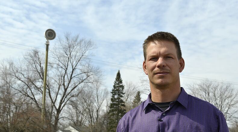 Howard Kitko, director of public service for the city of New Carlisle, talks about the city’s tornado sirens like the one in the background near the intersection of Walsh Drive and Lake Avenue on Tuesday. Moorefield Twp. recently received a grant to get six outdoor warning sirens. Bill Lackey/Staff