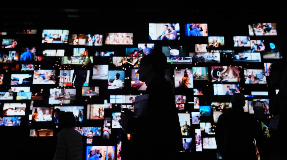 People walk past screens at the LG Electronics booth during the CES tech show Tuesday, Jan. 6, 2026, in Las Vegas. (AP Photo/Abbie Parr)