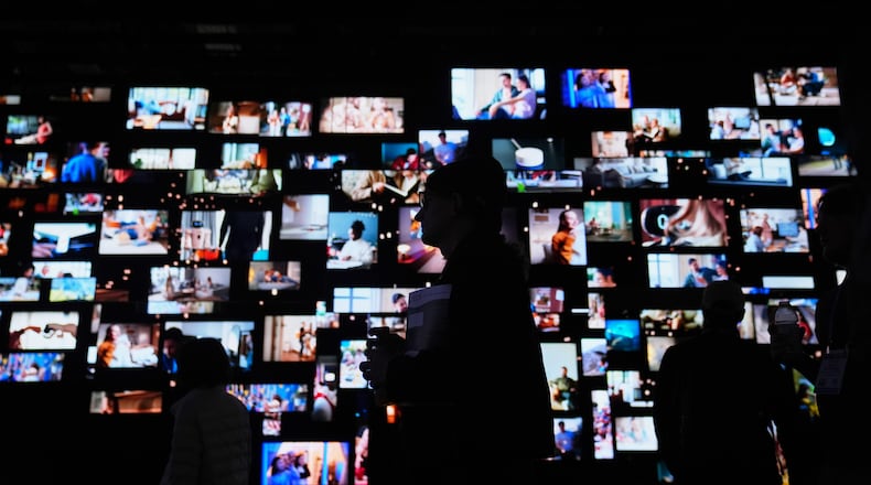 People walk past screens at the LG Electronics booth during the CES tech show Tuesday, Jan. 6, 2026, in Las Vegas. (AP Photo/Abbie Parr)