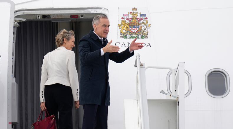 Canadian Prime Minister Mark Carney and his wife Diana Fox Carney board a government plane in Ottawa on Thursday, Feb. 26, 2026. (Adrian Wyld/The Canadian Press via AP)
