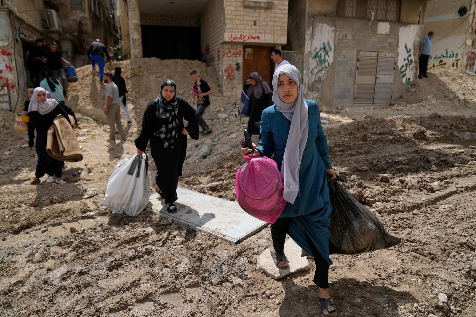 Residents of the now evacuated refugee camp of Tulkarem return to collect belongings before the destruction of their homes as Israeli forces prepare to carry out the demolition of 116 homes across the two refugee camps of the Israeli occupied West Bank city of Tulkarem, Friday, May 2, 2025. (AP Photo/Nasser Nasser)