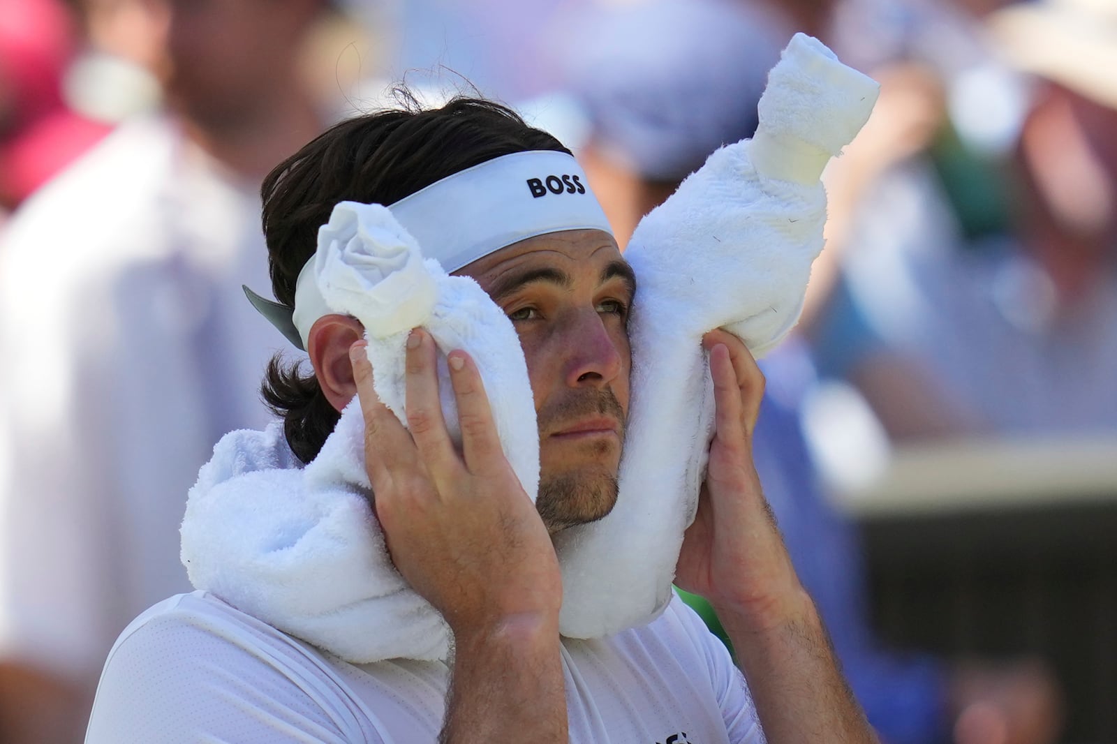 Taylor Fritz of the U.S. uses a towel packed with ice to cool during the men's semifinal singles match at the Wimbledon Tennis Championships in London, Friday, July 11, 2025.(AP Photo/Kirsty Wigglesworth)