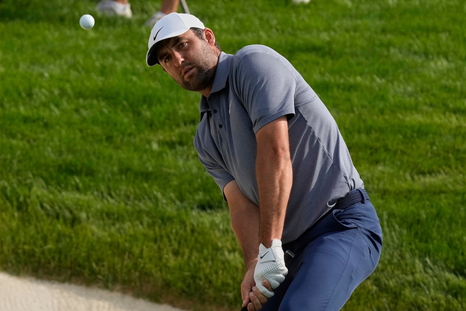 Scottie Scheffler chips onto the 18th green in the first round of the Memorial golf tournament Thursday, May 29, 2025, in Dublin, Ohio. (AP Photo/Sue Ogrocki)
