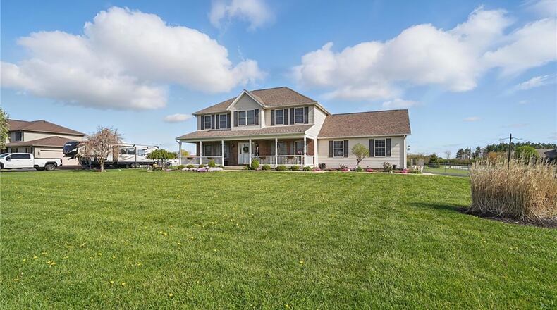 This traditional brick and vinyl two story is on an acre lot and has a full covered front porch and side entry two car garage.