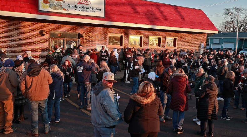 Family, friends and community members fill the parking lot of Gill's Quality Meat Market Monday, Jan. 9, 2023 during a candle light vigil for Thomas Gill, who was shot and killed last Thursday while driving his SUV in Springfield. BILL LACKEY/STAFF