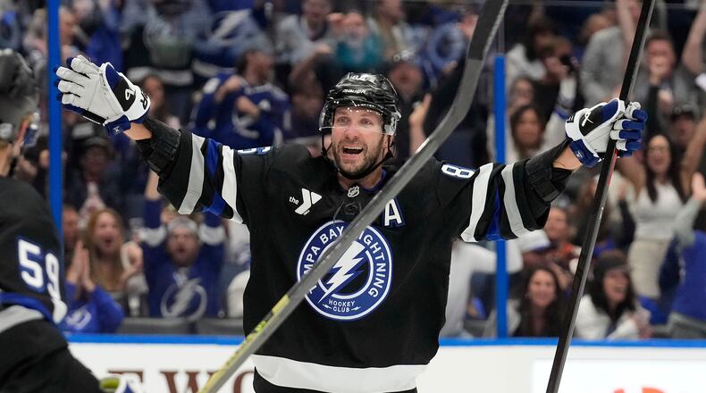 Tampa Bay Lightning right wing Nikita Kucherov (86) celebrates after picking up assist for his 1,000th career point on a goal by center Brayden Point during the second period of an NHL hockey game against the Anaheim Ducks Saturday, Oct. 25, 2025, in Tampa, Fla. (AP Photo/Chris O'Meara)