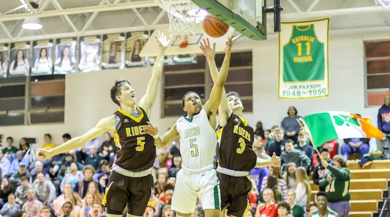 Catholic Central High School senior Trey Dunn shoots a layup between West Jefferson’s Joe Thompson (left) and Ben Casey (right) during the Irish’s 66-54 victory on Friday night at Jason Collier Gymnasium in Springfield. CONTRIBUTED PHOTO BY MICHAEL COOPER