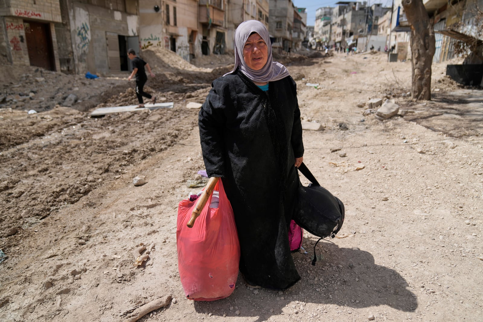 Residents of the now evacuated refugee camp of Tulkarem return to collect belongings before the destruction of their homes as Israeli forces prepare to carry out the demolition of 116 homes across the two refugee camps of the Israeli occupied West Bank city of Tulkarem, Friday, May 2, 2025. (AP Photo/Nasser Nasser)